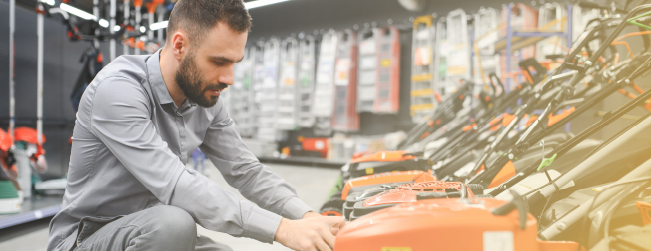 man looking at lawnmower